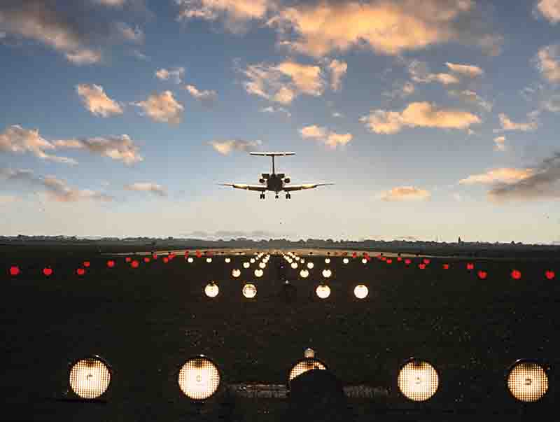 Ein Flugzeug hebt von der Starbahn ab und fliegt in den Sonnenuntergang